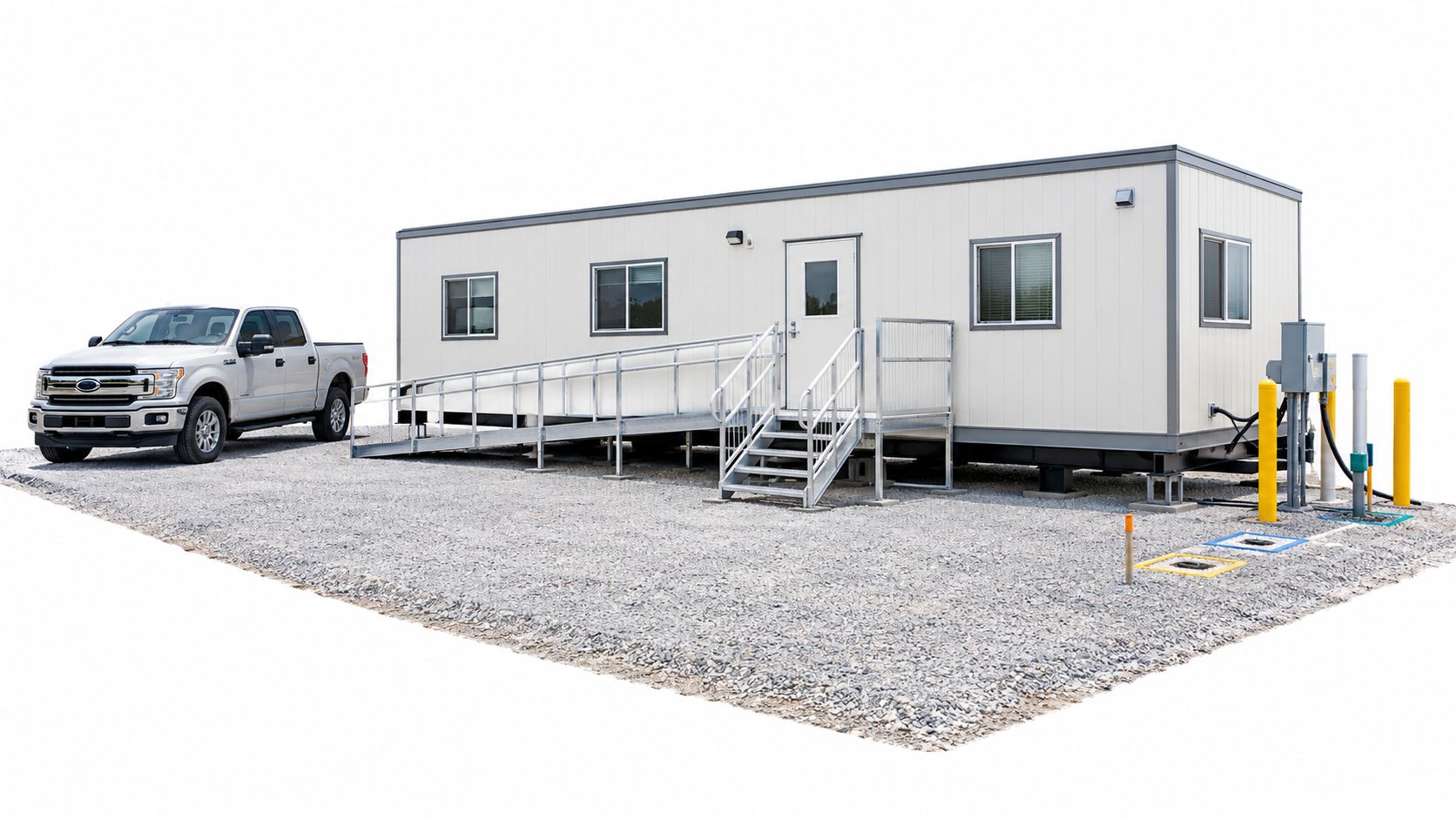 A silver pickup truck parked next to a portable trailer unit equipped with an accessibility ramp.